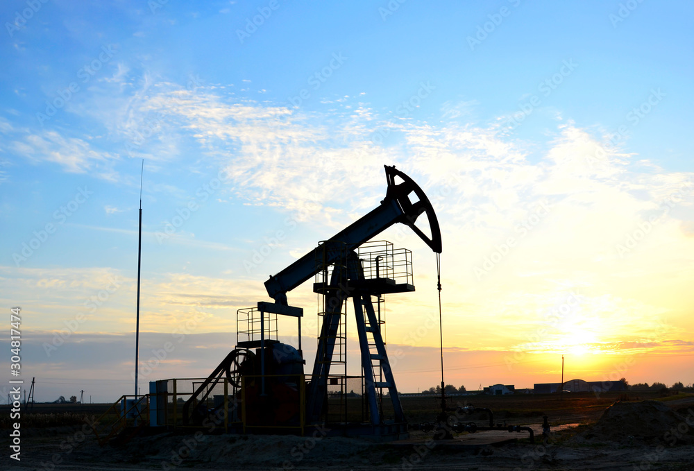 Oil drilling derricks at desert oilfield for fossil fuels output and crude oil production from the ground. Oil drill rig and pump jack. 