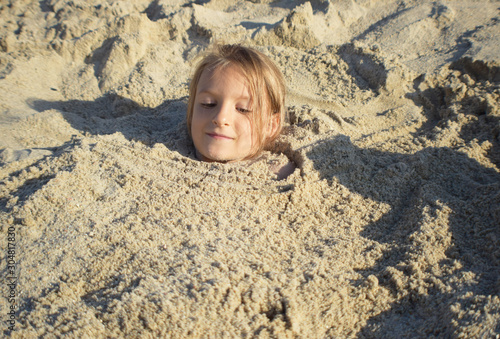 dziewczynka bawiąca się na plaży podczas letnich wakacji nad morzem 