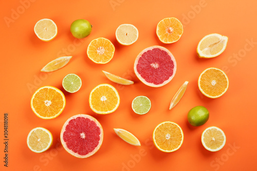 Flat lay composition with tangerines and different citrus fruits on orange background