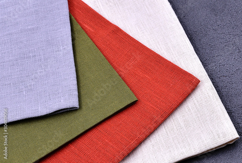 Colorful linen towels on a dark stone background. Close-up.