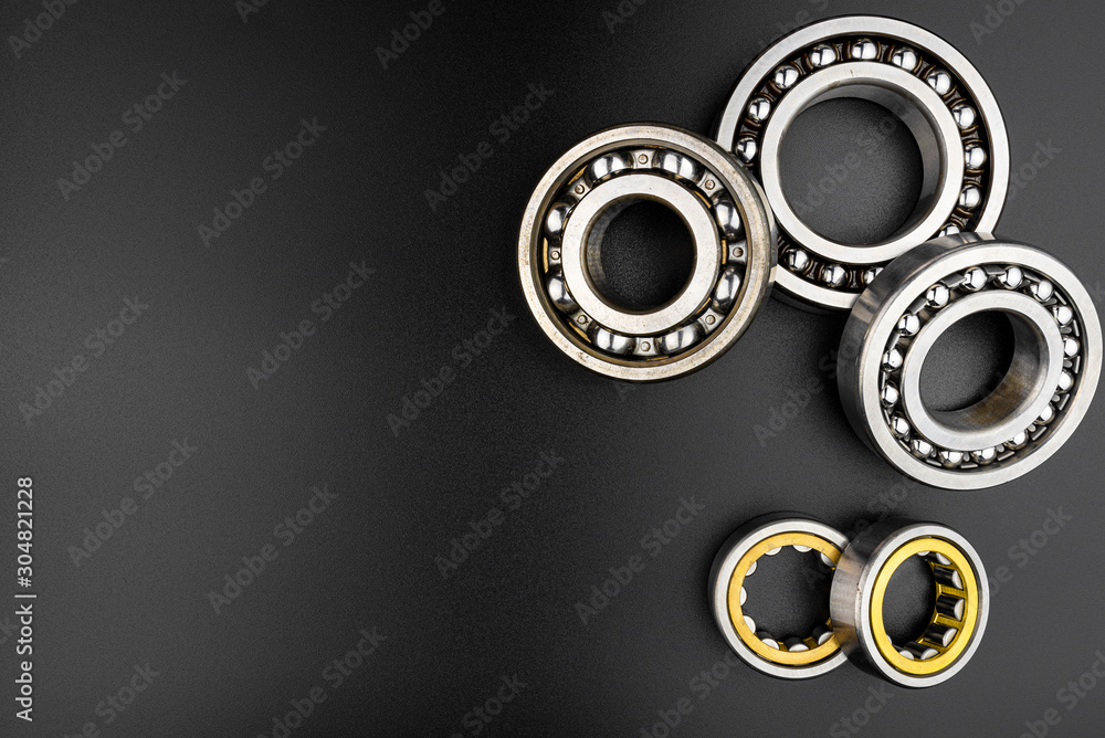 Ball bearing lying on a black background with copy space on the left side, flat view from above. Ball bearing lying on a black background with copy space on the left side, flat view from above.