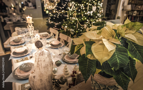 Gwiazda betlejemska nad szopką ze świętą rodziną na świątecznym stole na Boże Narodzenie, odświętnie nakryty stół wigilijny dla całej rodziny