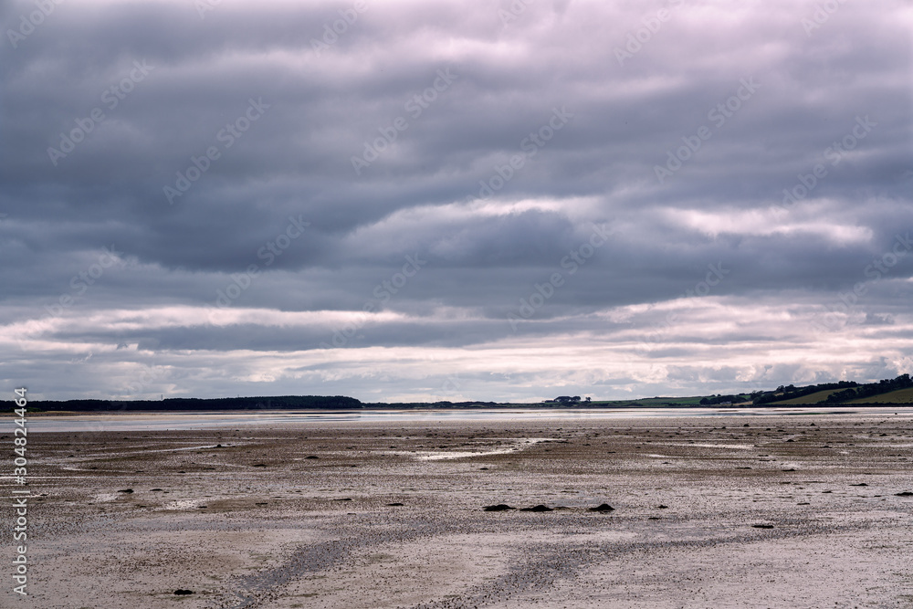 Clouds hanging above the beach in the evening.