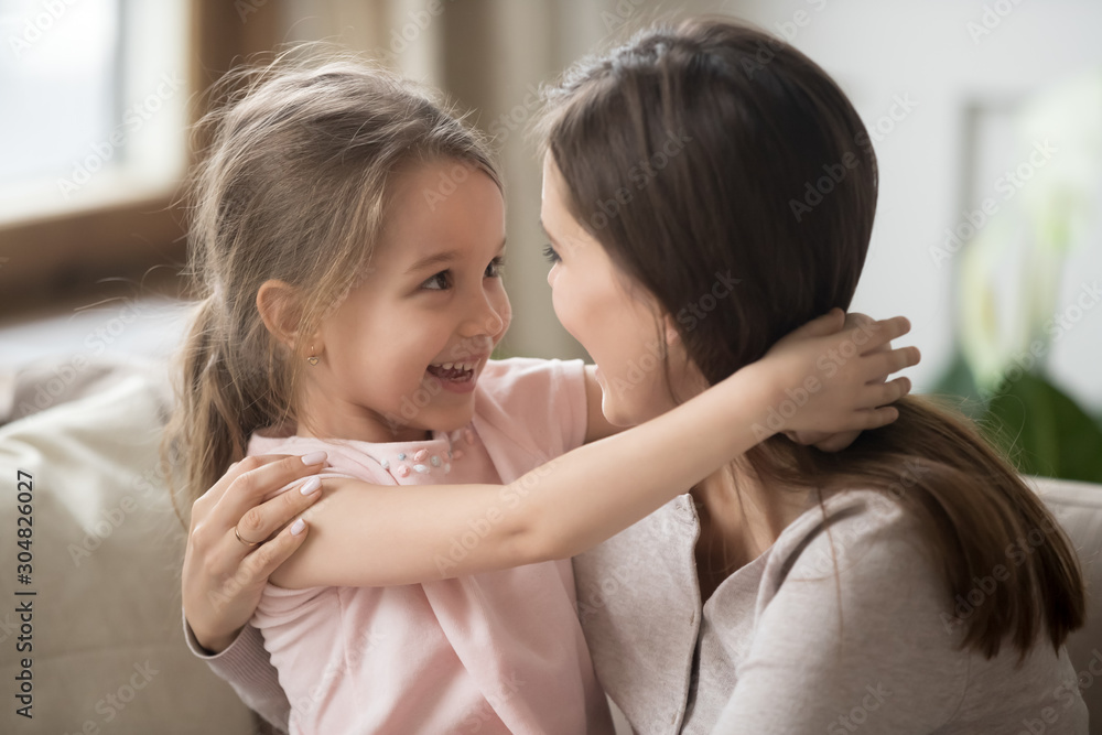 Happy little girl hug mom enjoying time together Happy little girl hug mom enjoying time together