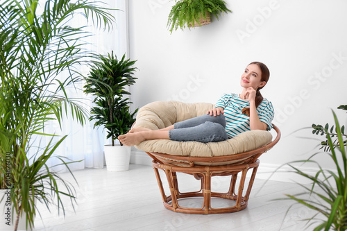 Young woman in room decorated with plants. Home design