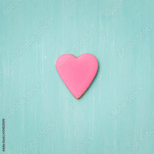 Cookies covered with pink icing on a turquoise background. Holiday concept