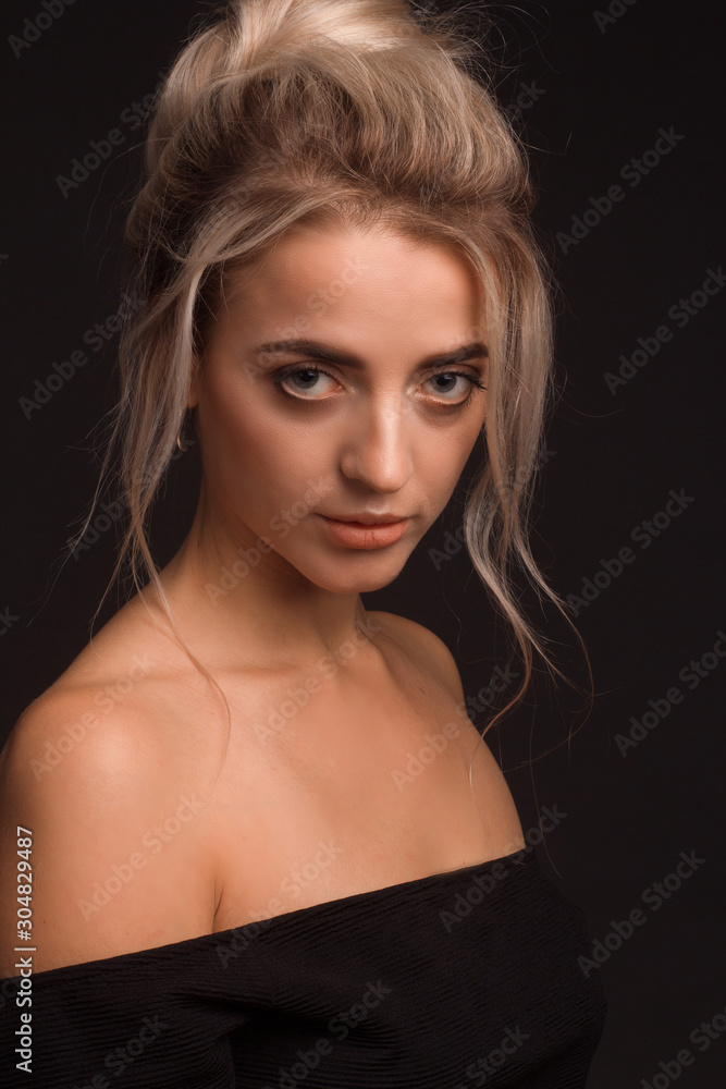 Studio portrait of a young beautiful girl on a black background Studio portrait of a young beautiful girl on a black background