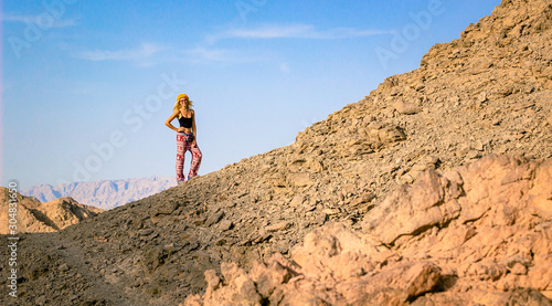 sexy girl in black short tank top with beautiful smiling face posing in travel and hiking time on desert sand rock wilderness mountain nature scenery landscape, extreme tourism concept picture © Артём Князь
