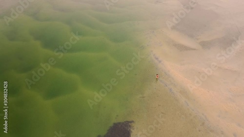 Aerial view of woman walking at the middle of Wallaga lake reserve, Australia. photo