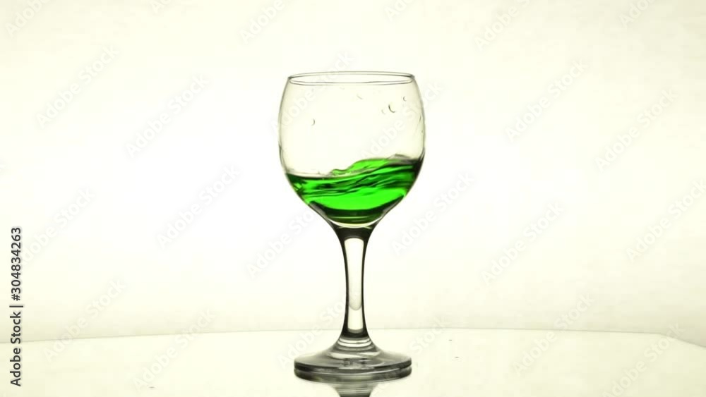 Splash of green liquid in wine glass Splash of green liquid in wine glass