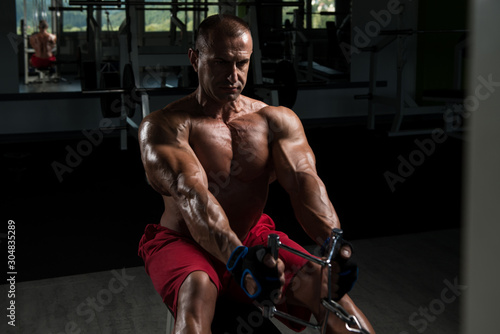 Bodybuilder Exercising Back In Gym