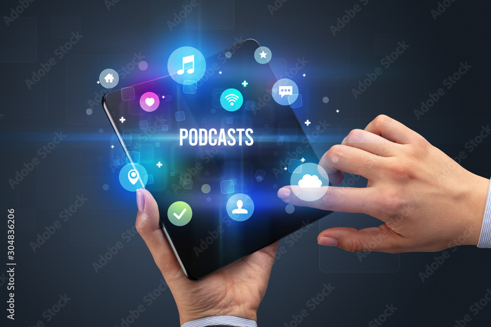Businessman holding a foldable smartphone with PODCASTS inscription, social media concept Businessman holding a foldable smartphone with PODCASTS inscription, social media concept
