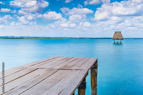 Hölzerner Steg ins Wasser mit Strohhütte