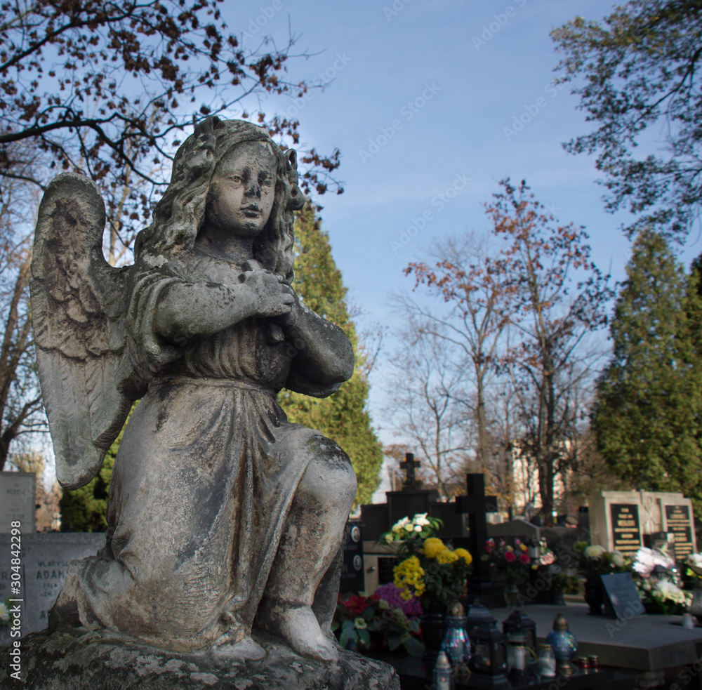 Fototapeta premium Monument and candles in the cemetery. All Saints Day in Poland.