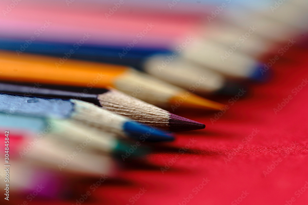 Color Pencils on red background. Colored Pencils Background. Crayons Close Up. - Image