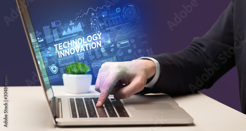 Businessman working on laptop with TECHNOLOGY INNOVATION inscription, cyber technology concept