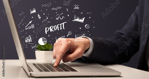 Businessman working on laptop with PROFIT inscription, modern business concept