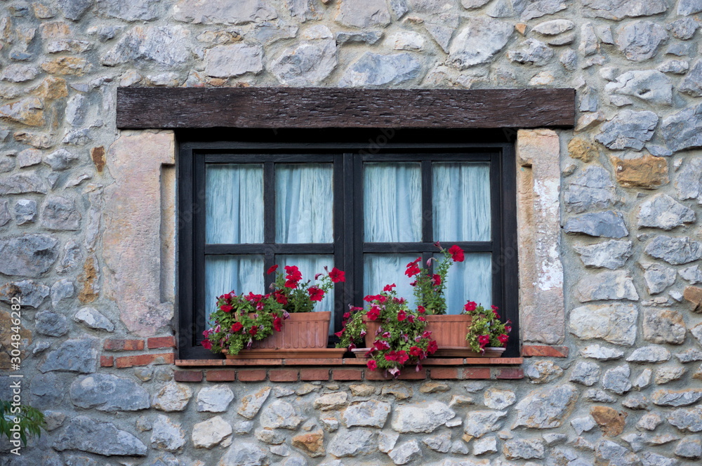 A flowery window in a typical house of Cantabria, Spain