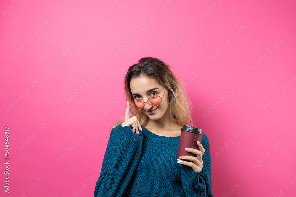 Glamor woman with a drink of coffee on a pink background Glamor woman with a drink of coffee on a pink background