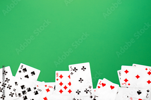 Deck of playing cards on green background table copy space photo