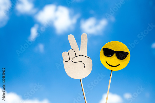 KYIV, UKRAINE - MAY 25, 2019: paper cut victory sign and smiling face in sunglasses