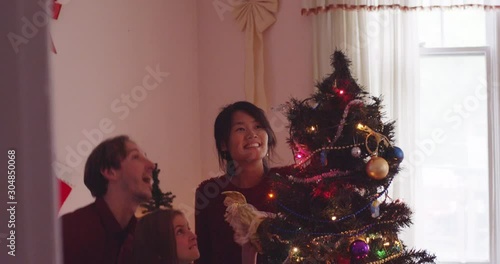 Father helps lift his daughter up to put the angel on the tree - shot on RED