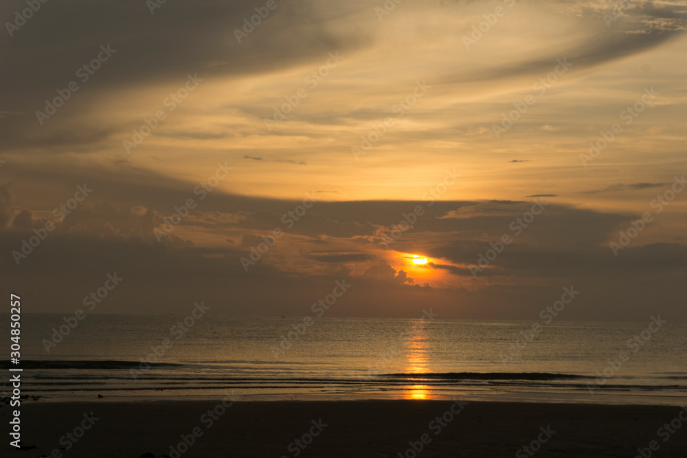 Beautiful dawn, morning sun rises by the sea. Scenic beach, coastline, rocks, cloudscape and skyline photography. Sunrise during the early hours of a summer morning by the beach. Sunset by the beach.
