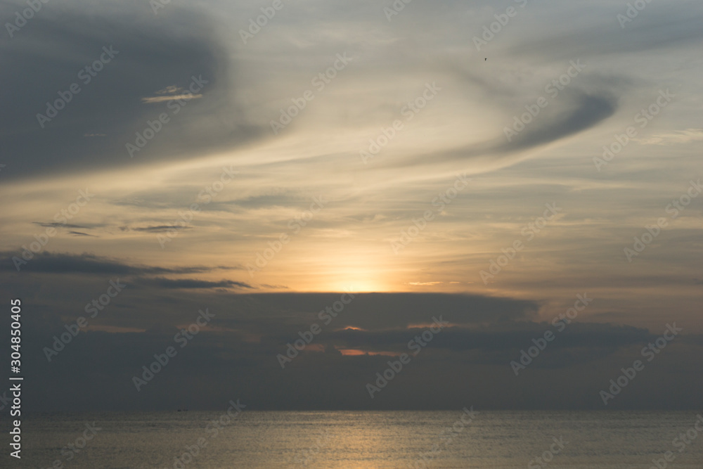 Beautiful dawn, morning sun rises by the sea. Scenic beach, coastline, rocks, cloudscape and skyline photography. Sunrise during the early hours of a summer morning by the beach. Sunset by the beach.