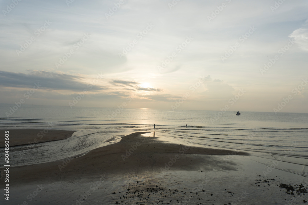 Obraz premium Beautiful dawn, morning sun rises by the sea. Scenic beach, coastline, rocks, cloudscape and skyline photography. Sunrise during the early hours of a summer morning by the beach. Sunset by the beach.