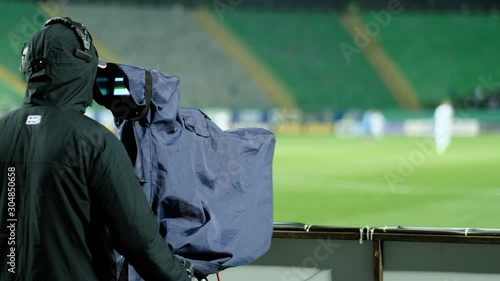 A professional cameraman shoots a football match. Broadcasting a football match