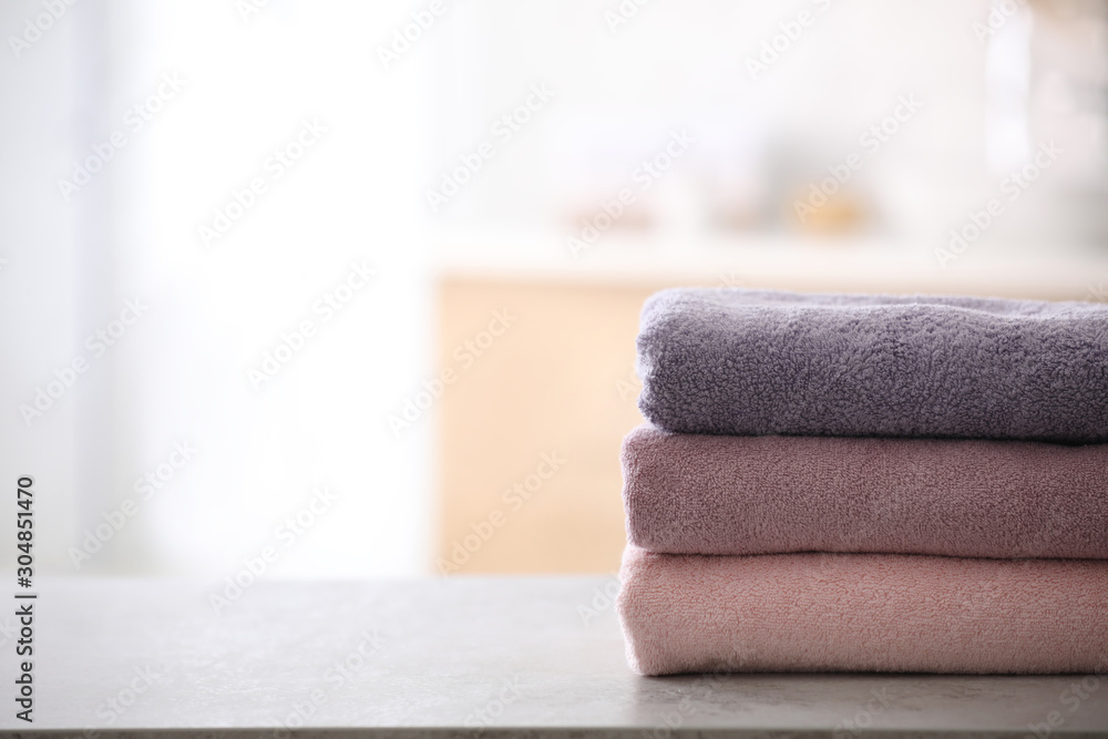Stack of fresh towels on table in bathroom. Space for text Stack of fresh towels on table in bathroom. Space for text