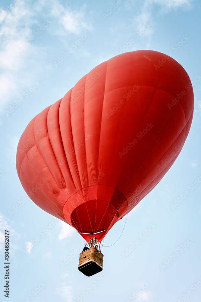 Fototapeta premium Heart shaped balloon soars in the sky