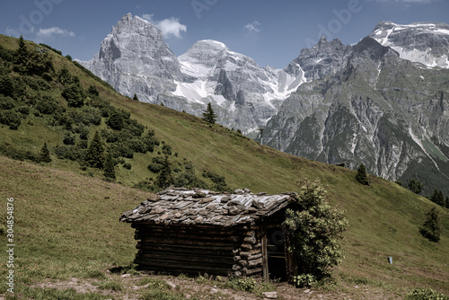 Mountain in Italy Alpine pastures with a deep blue lake, green meadows and a blue sky with fleecy clouds, in summer