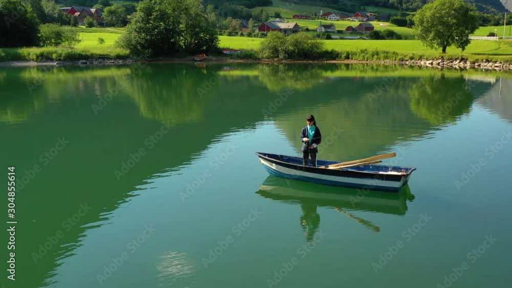 Woman on the boat catches a fish on spinning in Norway. Woman on the boat catches a fish on spinning in Norway.