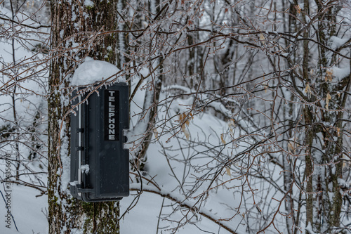 Telephone box in the wilderness winter landscape photo