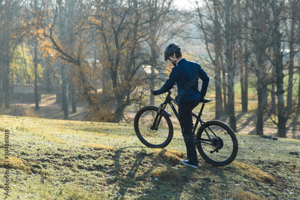 Cyclist in pants and fleece jacket on a modern carbon hardtail bike with an air suspension fork. The guy on the top of the hill rides a bike.