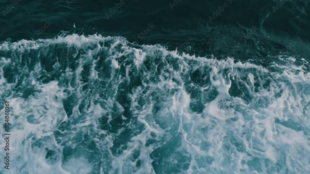 Beautiful turquoise sea water with waves and white foam close up top view. The ship floats on the sea and cuts the waves Beautiful turquoise sea water with waves and white foam close up top view. The ship floats on the sea and cuts the waves
