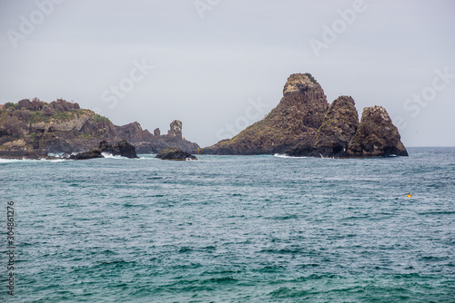 One of the rocky islands of Cyclops seen from Aci Castello town on Sicily Island, Italy