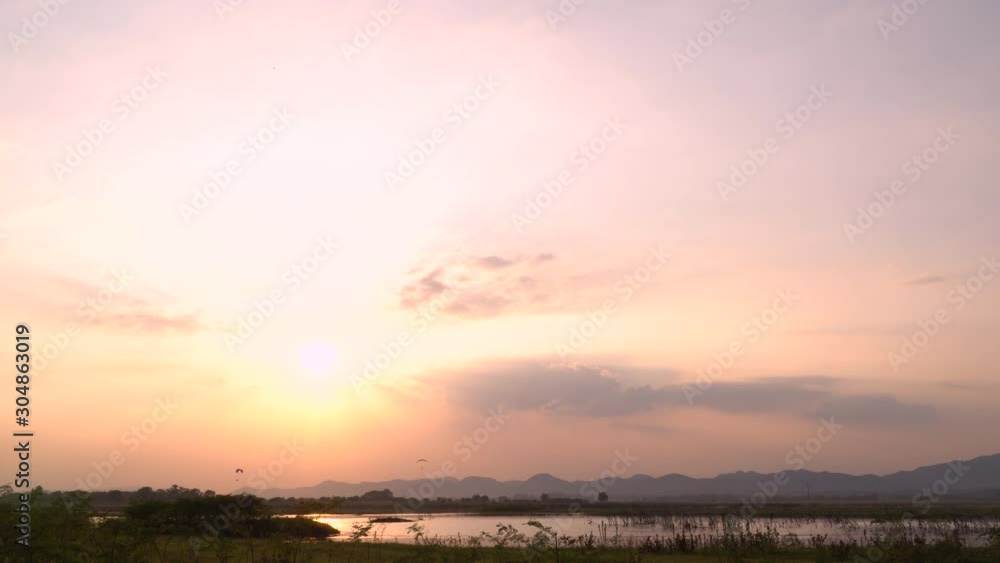 the reservoir with flying paramotor on lower level as sunset time the reservoir with flying paramotor on lower level as sunset time