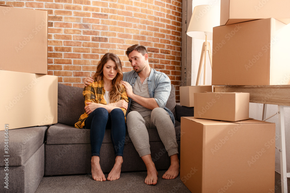 Confused couple of having to move and arrange all the packages. Concept of success, delusion, change and future Confused couple of having to move and arrange all the packages. Concept of success, delusion, change and future