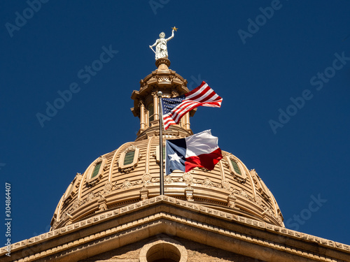 US flag and flag of Texas flying proudly above the Texas State Capital  photo