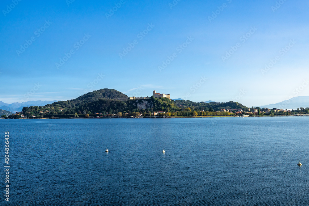 View of Rocca di Angera (Borromeo Castle) from Arona waterfront on the shores of Lake Maggiore, Piedmont, Italy.