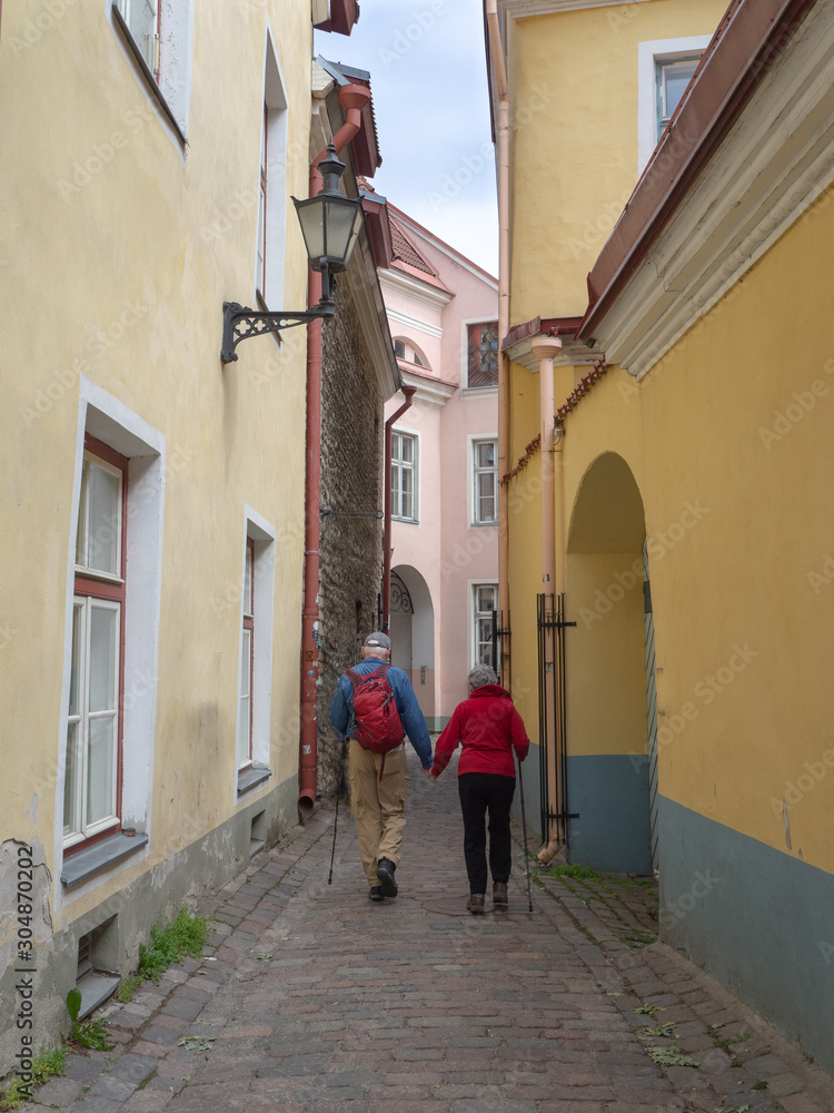 Senior Couple holding hands walking through old European town in Tallin, Estonia
