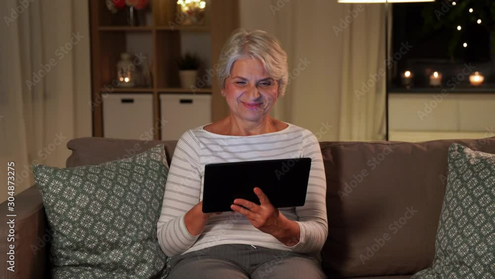 technology, old age and people concept - happy senior woman with tablet pc computer at home in evening technology, old age and people concept - happy senior woman with tablet pc computer at home in evening