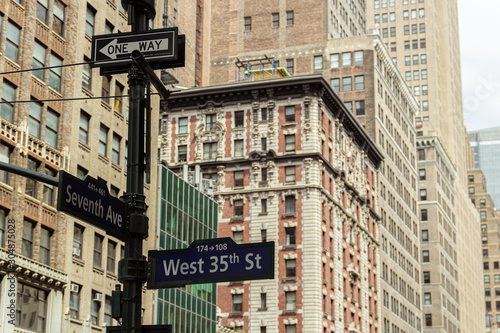 Signs in the urban center of New York city, surrounded by imposing buildings