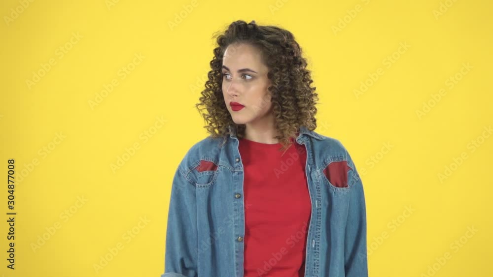 Charming girl looks around, covers her mouth with her hand and whispers the secret and making a hush gesture, slow motion Charming girl looks around, covers her mouth with her hand and whispers the secret and making a hush gesture, slow motion