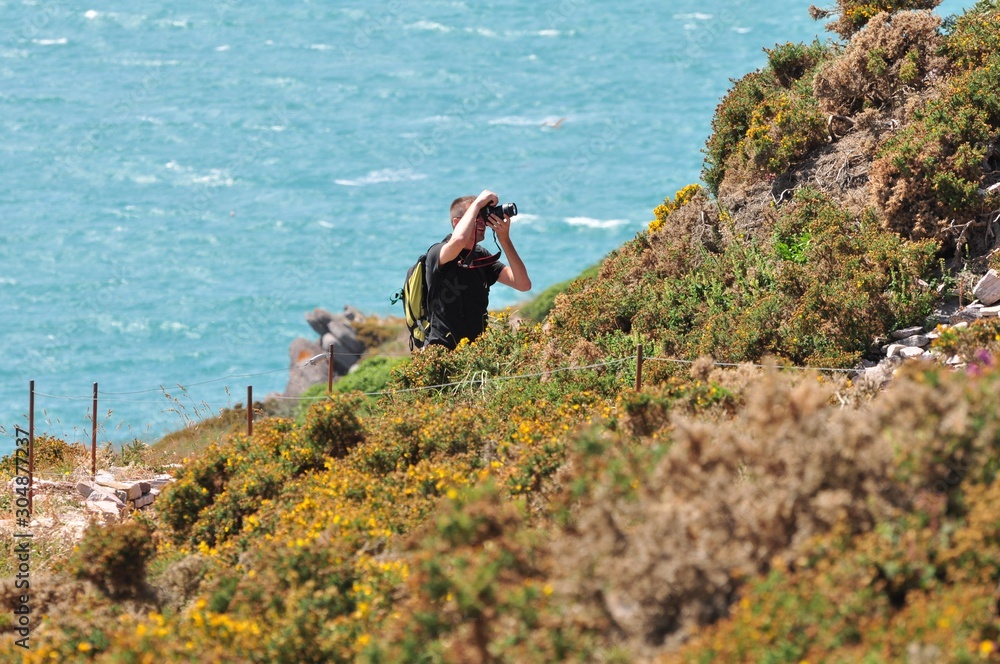 Un homme qui prend une photo sur la côte à Erquy en Bretagne