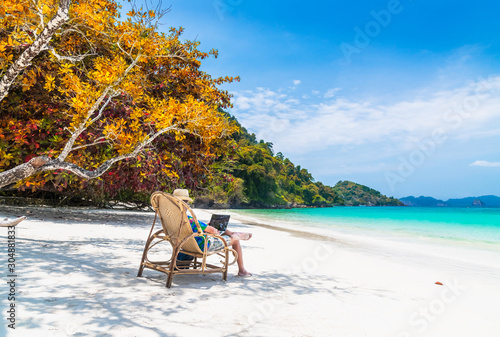 Business man on summer holiday vacation trip, Traveler man relaxing on beautiful natural white sand beach using laptop, Landmark tourist travel Myanmar Thailand beach, Tourism destination scenery Asia