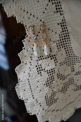 earrings set in a white lace towel, making of bride, pendant pearl earring	