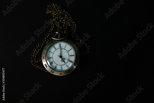 The watch carries an antique bag placed on a black background.